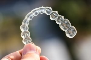 Holding invisalign braces on bokeh background